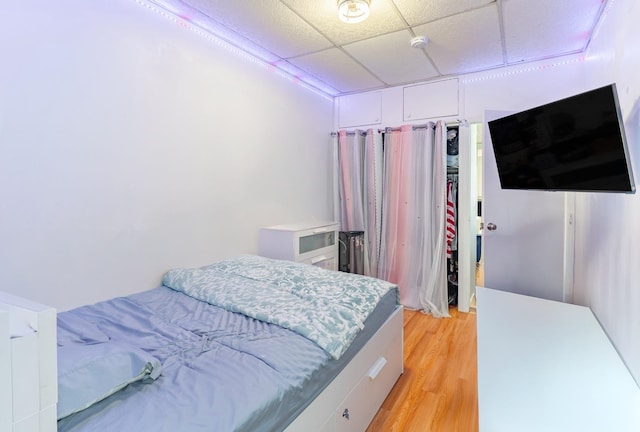 bedroom featuring a paneled ceiling and light hardwood / wood-style flooring