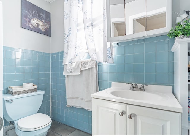 bathroom with tile walls, tile patterned flooring, vanity, and toilet