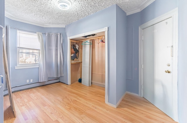 foyer featuring a baseboard radiator, light hardwood / wood-style flooring, a textured ceiling, and crown molding