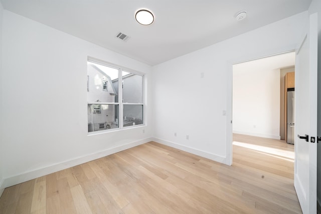 unfurnished room with light wood-type flooring