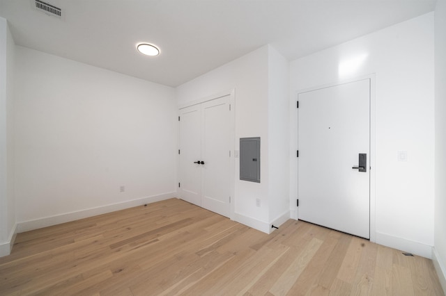 spare room featuring light wood-type flooring and electric panel