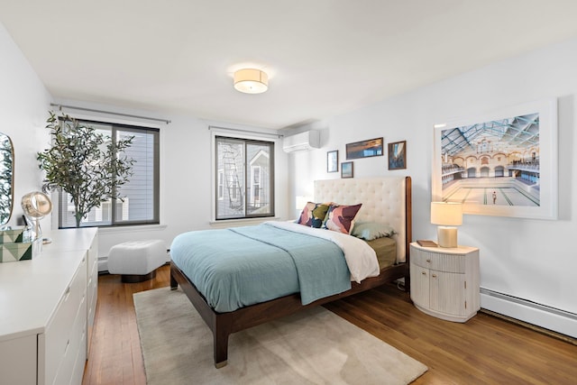 bedroom featuring a baseboard radiator, a wall mounted air conditioner, and wood finished floors