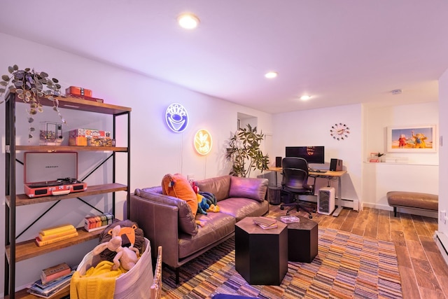 living area with recessed lighting, a baseboard heating unit, and wood finished floors