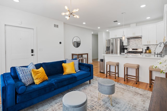 185 Gates Ave, Jersey City, NJ 07305 - living room featuring visible vents, light wood-style floors, and a chandelier