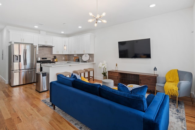 185 Gates Ave, Jersey City, NJ 07305 - living room with recessed lighting, baseboards, a chandelier, and light wood-type flooring