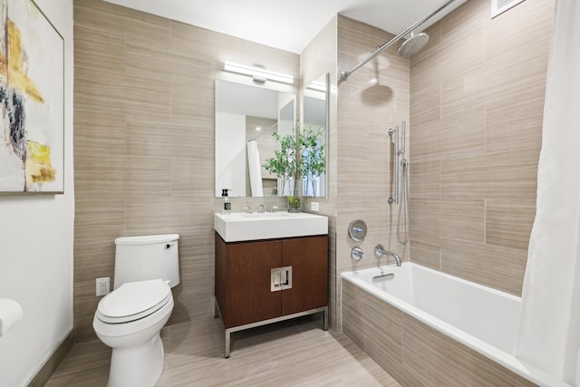 full bathroom featuring tile patterned floors, shower / bath combo with shower curtain, tile walls, toilet, and vanity