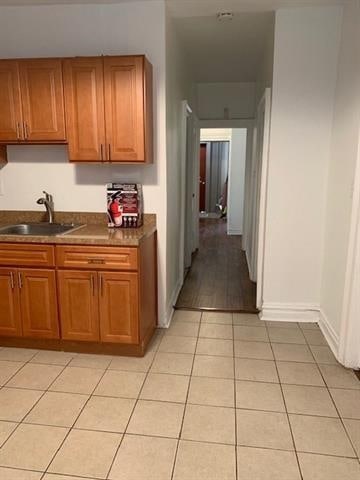 798 Grand St, Jersey City, NJ 07304 - kitchen with dark countertops, light tile patterned floors, and brown cabinets