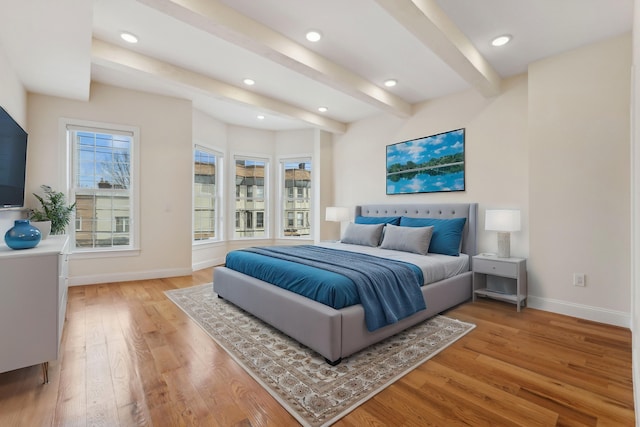 bedroom with beam ceiling, recessed lighting, light wood-style flooring, and baseboards