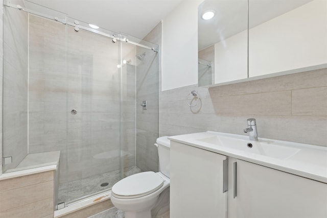 full bath featuring vanity, tile walls, toilet, and a shower stall