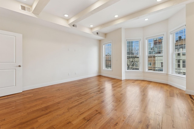 unfurnished room featuring beamed ceiling, light wood-style flooring, and baseboards