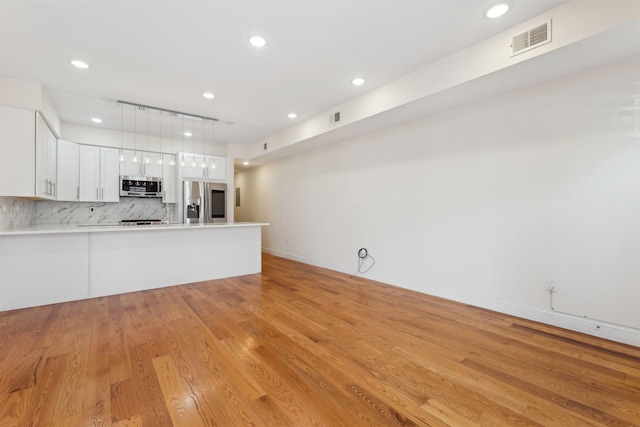 unfurnished living room with recessed lighting, visible vents, baseboards, and light wood-style flooring