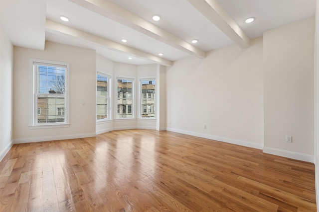 spare room featuring beam ceiling, recessed lighting, baseboards, and light wood finished floors