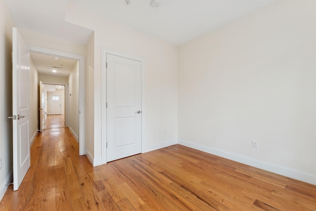 unfurnished bedroom with baseboards and light wood-style floors