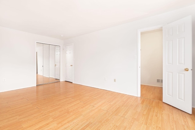 unfurnished room featuring visible vents and light wood finished floors