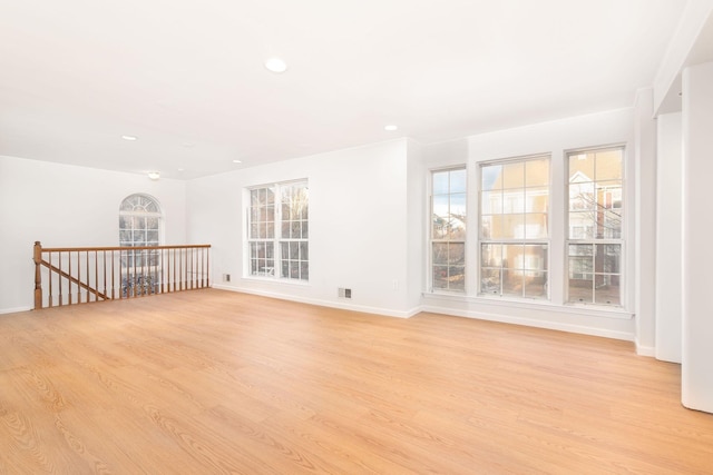 empty room featuring baseboards, light wood-style flooring, and recessed lighting