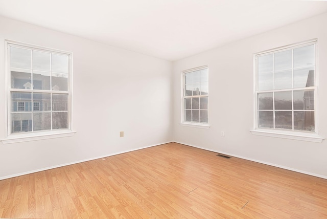 empty room featuring light wood-type flooring and baseboards