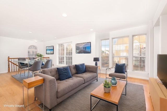 living area with light wood-type flooring, baseboards, and recessed lighting