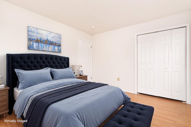 bedroom with light wood finished floors and a closet