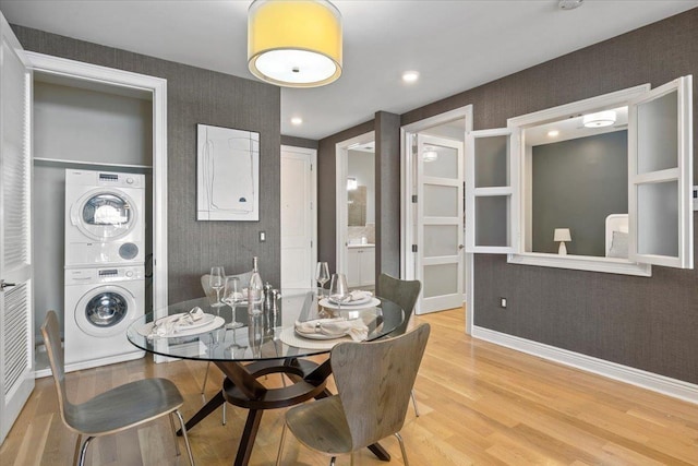9 Somerset Ln Unit 118, Edgewater, NJ 07020 - dining area with stacked washer / drying machine, wallpapered walls, light wood finished floors, and baseboards