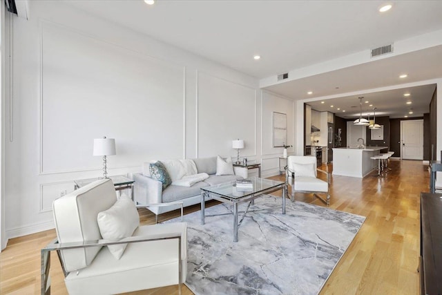 9 Somerset Ln Unit 118, Edgewater, NJ 07020 - living area featuring a decorative wall, light wood-style floors, and recessed lighting