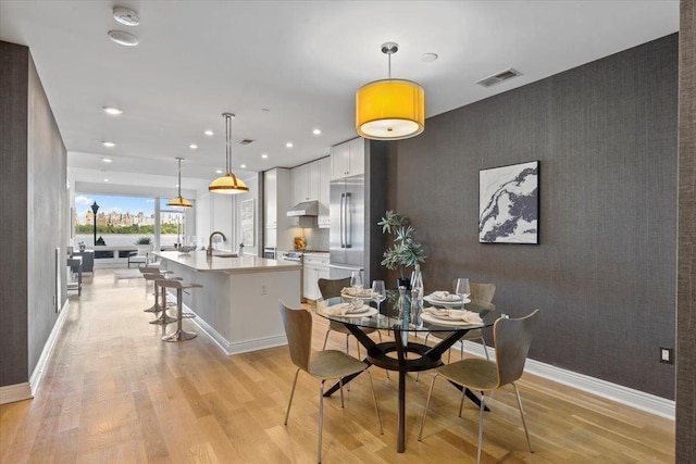 9 Somerset Ln Unit 118, Edgewater, NJ 07020 - dining area with an accent wall, light wood-style floors, recessed lighting, and baseboards