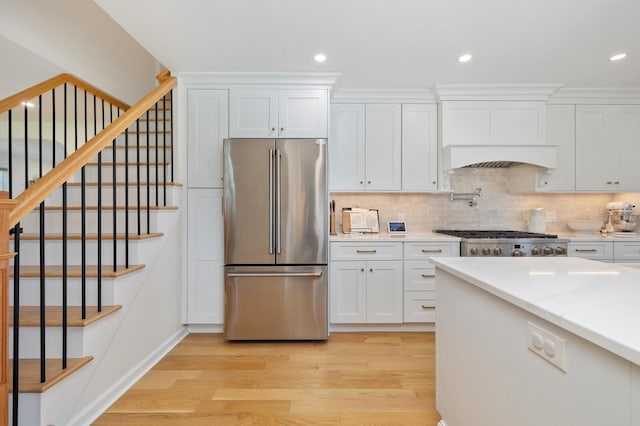 11 Dean Ct, Rutherford, NJ 07070 - kitchen featuring high quality fridge, light wood-style floors, white cabinetry, tasteful backsplash, and stove