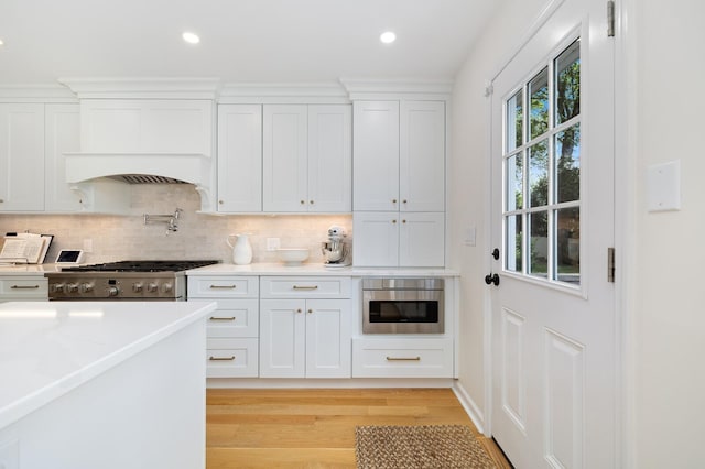 11 Dean Ct, Rutherford, NJ 07070 - kitchen featuring high end stainless steel range, white cabinetry, backsplash, light wood-style floors, and recessed lighting