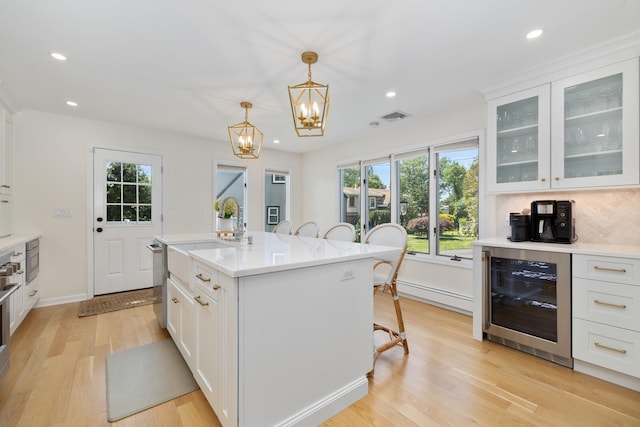 11 Dean Ct, Rutherford, NJ 07070 - kitchen featuring wine cooler, a breakfast bar, light wood-type flooring, a chandelier, and light countertops