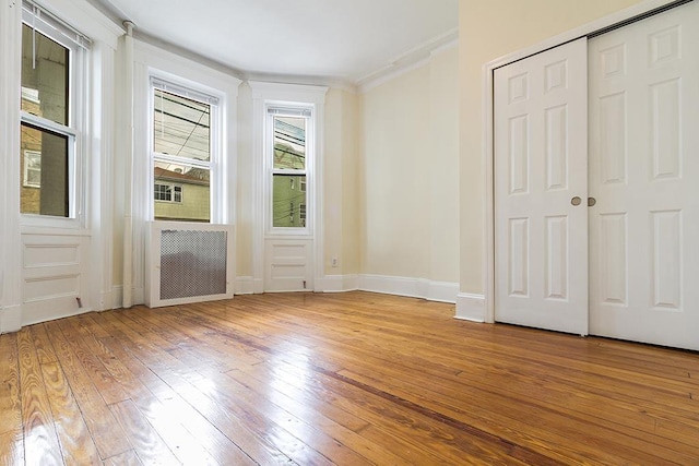 179 Beacon Ave, Jersey City, NJ 07306 - unfurnished bedroom featuring hardwood / wood-style flooring, ornamental molding, baseboards, and a closet