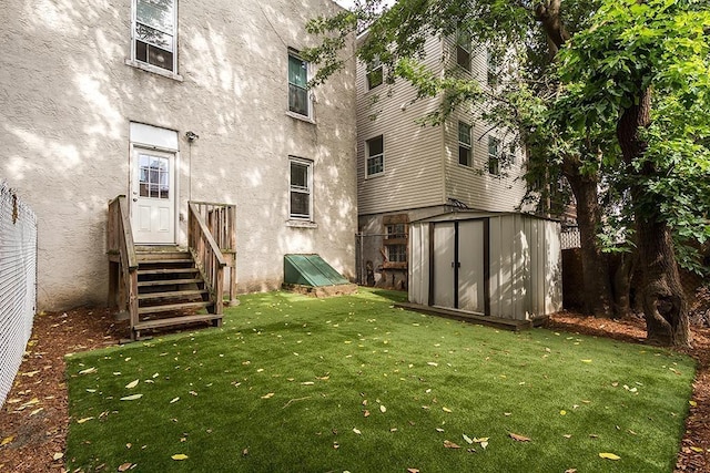 179 Beacon Ave, Jersey City, NJ 07306 - rear view of property with stucco siding, a storage shed, a yard, and an outbuilding