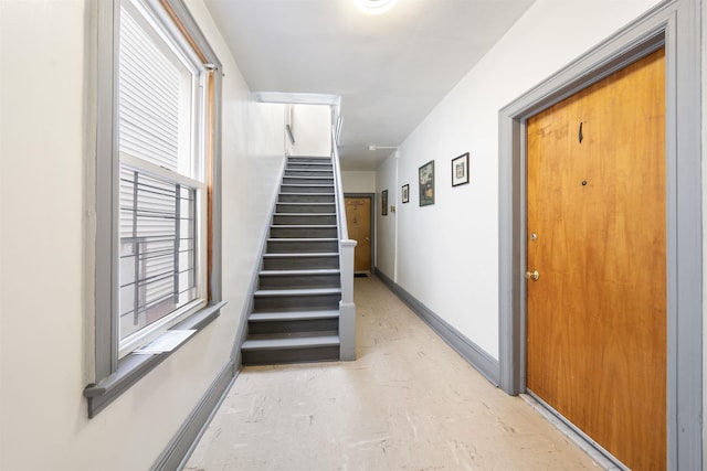 interior space featuring stairway and baseboards