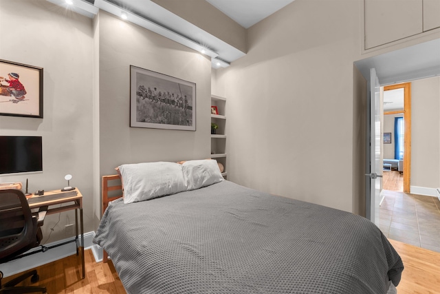 bedroom featuring baseboards and wood finished floors