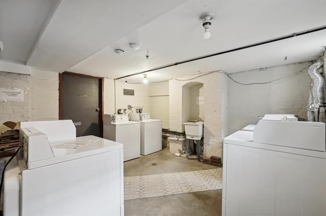 common laundry area featuring separate washer and dryer and a sink