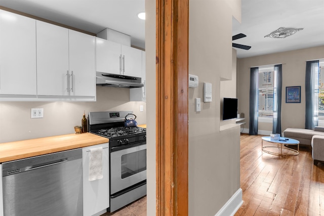 kitchen featuring a ceiling fan, baseboards, white cabinets, under cabinet range hood, and stainless steel appliances