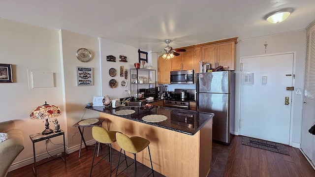 380 Mountain Rd Unit 210, Union City, NJ 07087 - kitchen featuring a breakfast bar area, dark wood finished floors, stainless steel appliances, a ceiling fan, and a peninsula