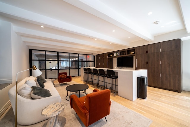 living room with recessed lighting, beamed ceiling, baseboards, and light wood-style floors