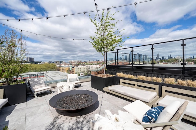 view of patio with a view of city and a fire pit