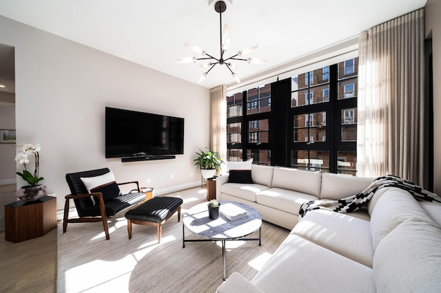 living area featuring baseboards, light wood-style flooring, and a notable chandelier