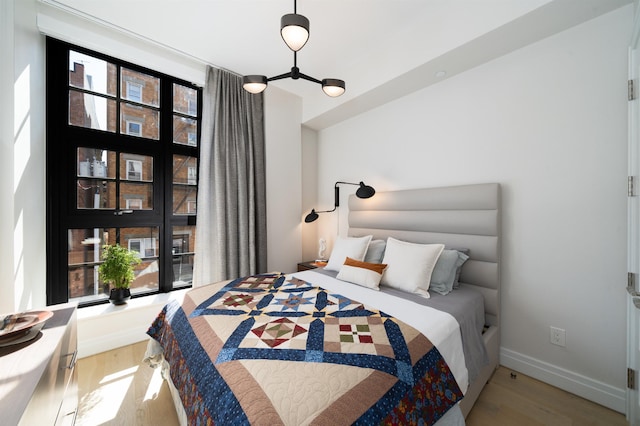 bedroom with baseboards and light wood-type flooring