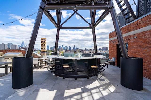 view of patio with a city view, outdoor dining space, area for grilling, and outdoor dry bar