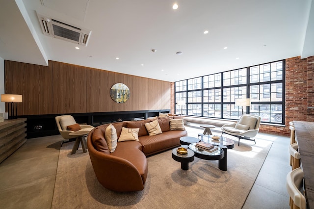 living room with recessed lighting and wood walls