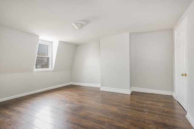 unfurnished room featuring baseboards and dark wood-style flooring