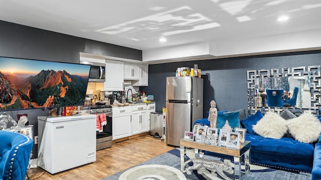 2212 Grand Ave, North Bergen, NJ 07047 - kitchen featuring stainless steel appliances, a sink, light wood finished floors, and white cabinets