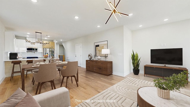 living room featuring an inviting chandelier and light hardwood / wood-style floors