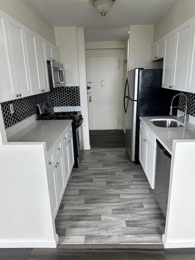 1225 Kennedy Blvd Unit 4J, Bayonne, NJ 07002 - kitchen featuring stainless steel appliances, white cabinetry, decorative backsplash, and light countertops