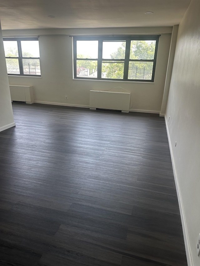 1225 Kennedy Blvd Unit 4J, Bayonne, NJ 07002 - empty room with radiator heating unit and dark wood finished floors