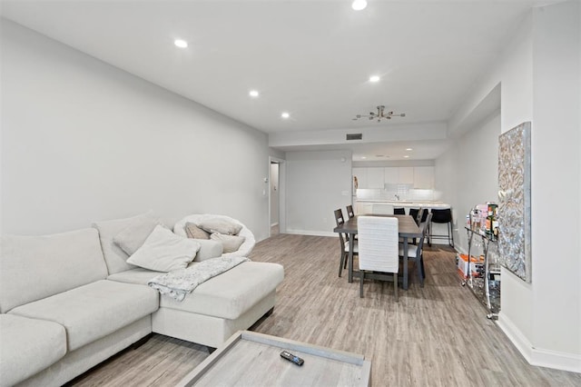 living area featuring visible vents, baseboards, recessed lighting, and light wood-type flooring
