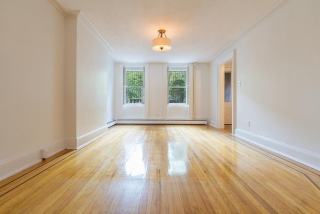 spare room with crown molding, a baseboard radiator, and light wood-type flooring