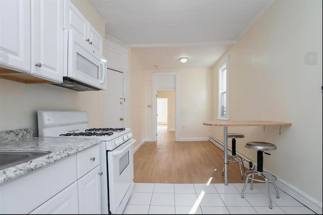 kitchen featuring white cabinetry, light hardwood / wood-style flooring, light stone counters, and white appliances