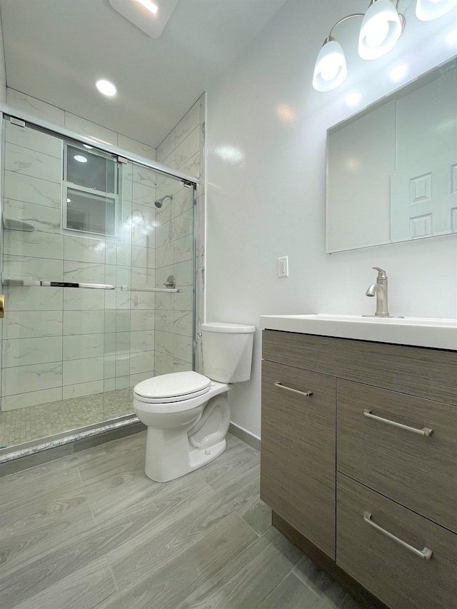 bathroom with vanity, toilet, and a shower with shower door